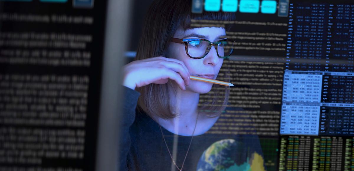 Woman in glasses looking into a computer 