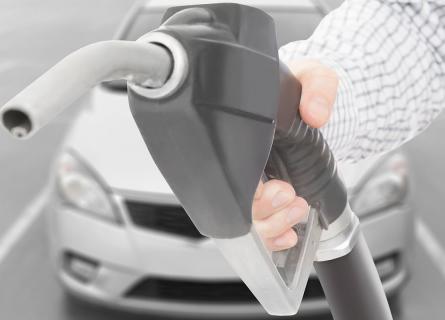 Black color fuel pump gun in hand with white car on background