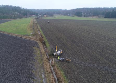People working with the soil in Finnish field landscape