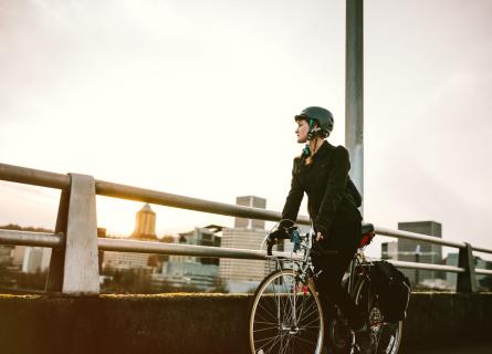Nainen pyöräilee sillalla