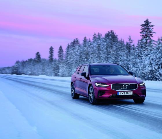 red volvo driving on snowy road