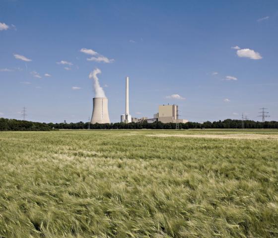 The picture shows a power plant and a grain field.